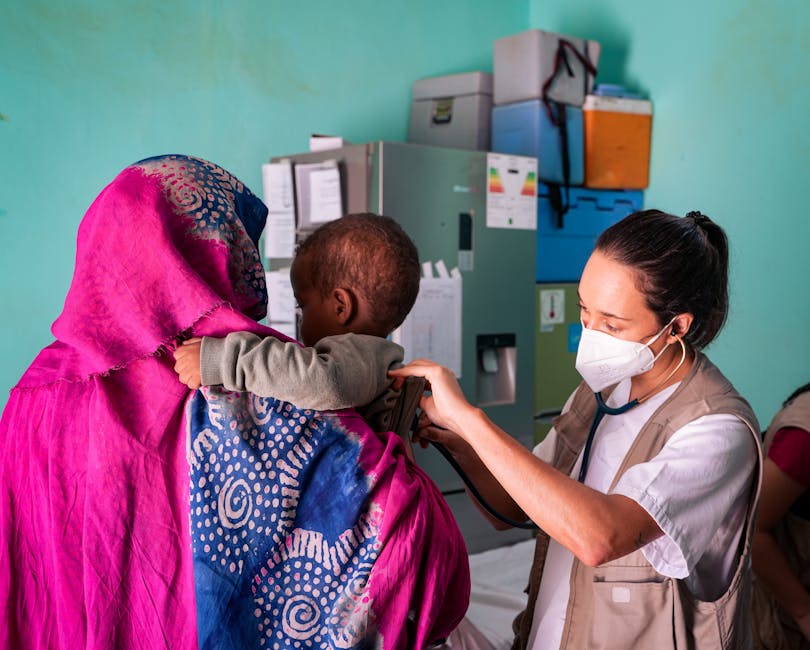 A healthcare worker examines a child held by their mother in a Tinduf clinic.